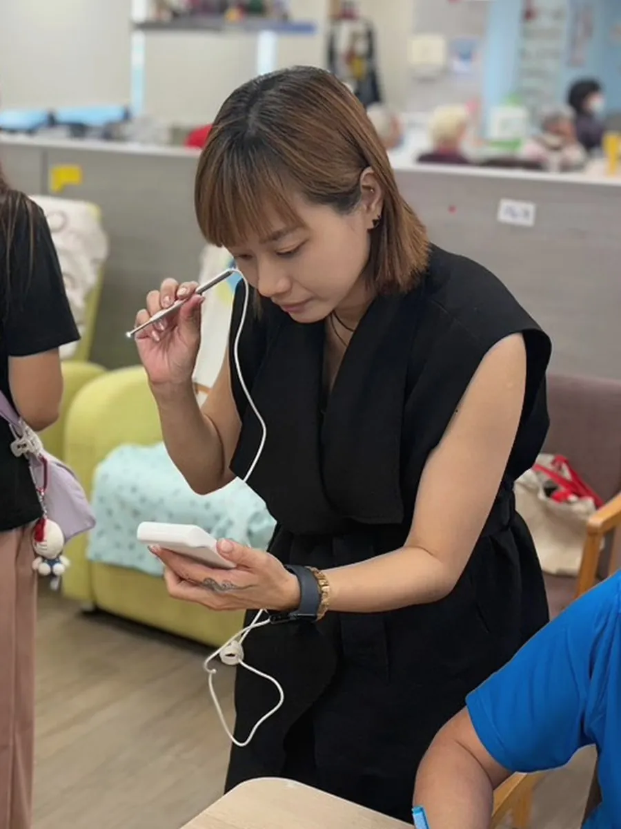 臻息主理人、采耳師 Abbie 張臻伶手持采耳工具與耳道內視鏡